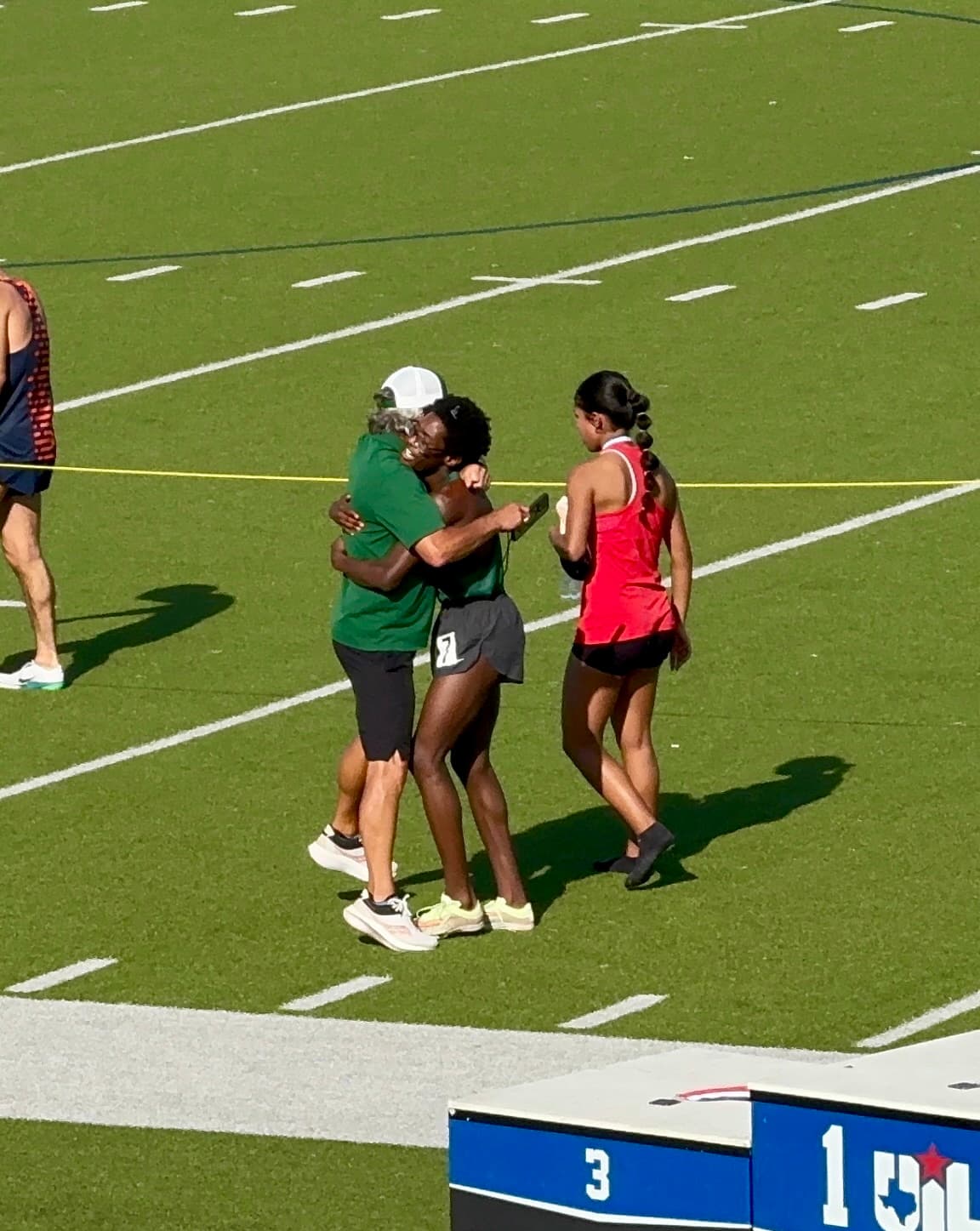 Coach and athlete embracing after a race finish